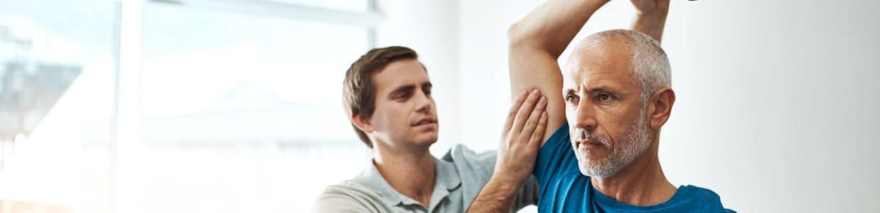 Kiné fait un exercice de mobilité à un patient