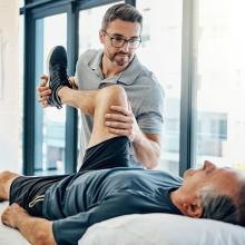 Kinésithérapeute manipule un patient allongé sur la tâble