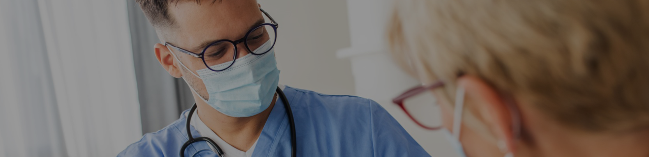 Un jeune infirmier prend la tension d'une patiente âgée