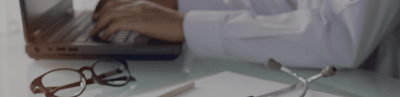 Médecin assis à son bureau, travaille sur son ordinateur