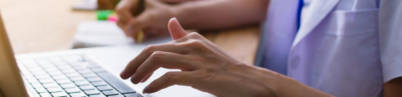 Soignante réalise son CV sur son ordinateur