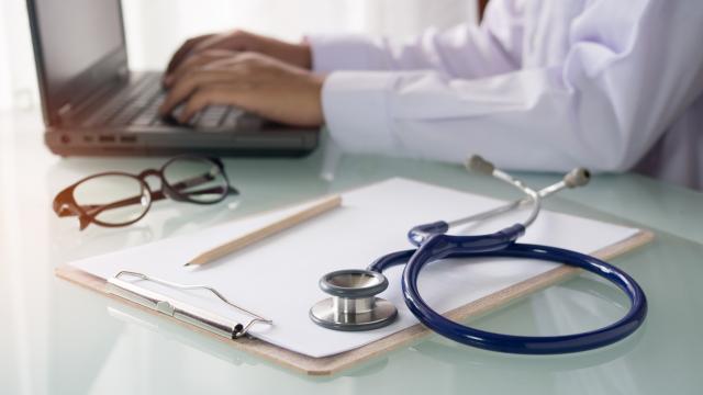 Médecin assis à son bureau, travaille sur son ordinateur