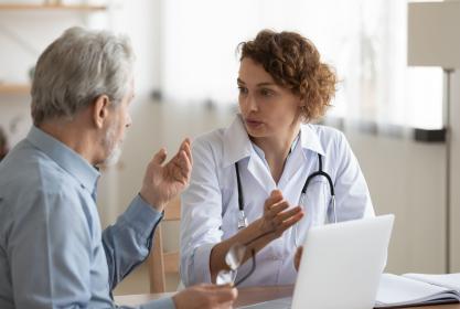 Infirmière discute avec un patient devant un ordinateur