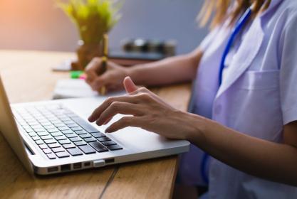 Médecin travaille sur son ordinateur pour étoffer son CV