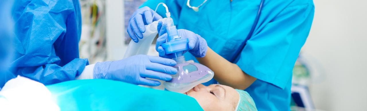 Infirmier anesthésiste qui participe à une opération avec une personne allongée sur un lit d'hôpital