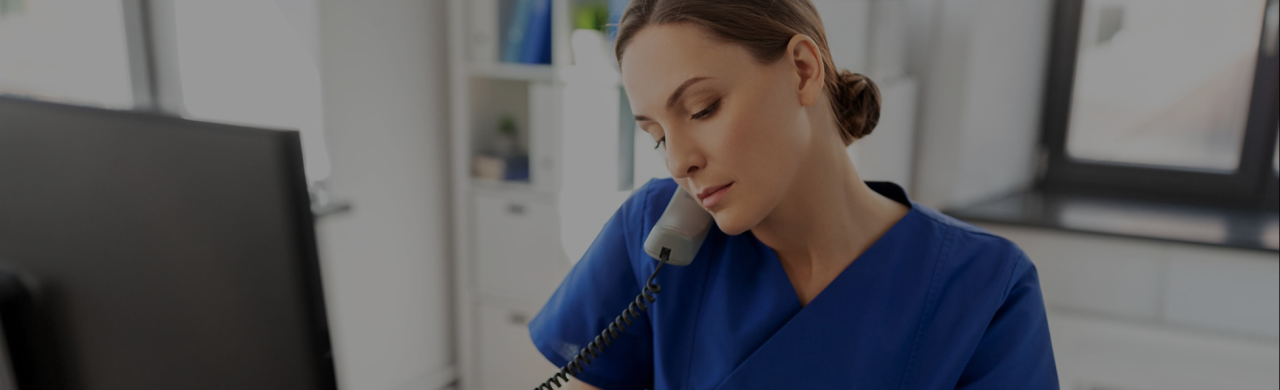 Infirmière au téléphone devant son ordinateur