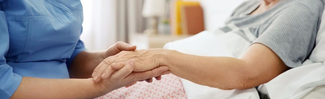 Aide-soignante qui aide une patiente âgée