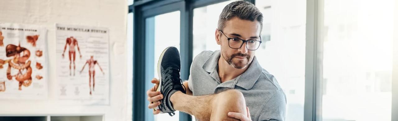 Kinésithérapeute manipule un patient allongé sur la table