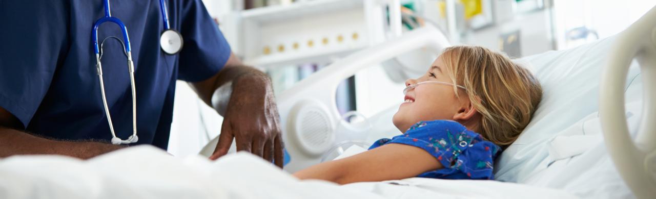 Infirmier Puériculteur s'occupe d'un enfant sur un lit d'hôpital
